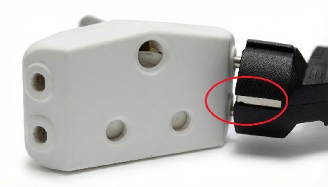 Schuko plug inserted into a two-pin unearthed adapter